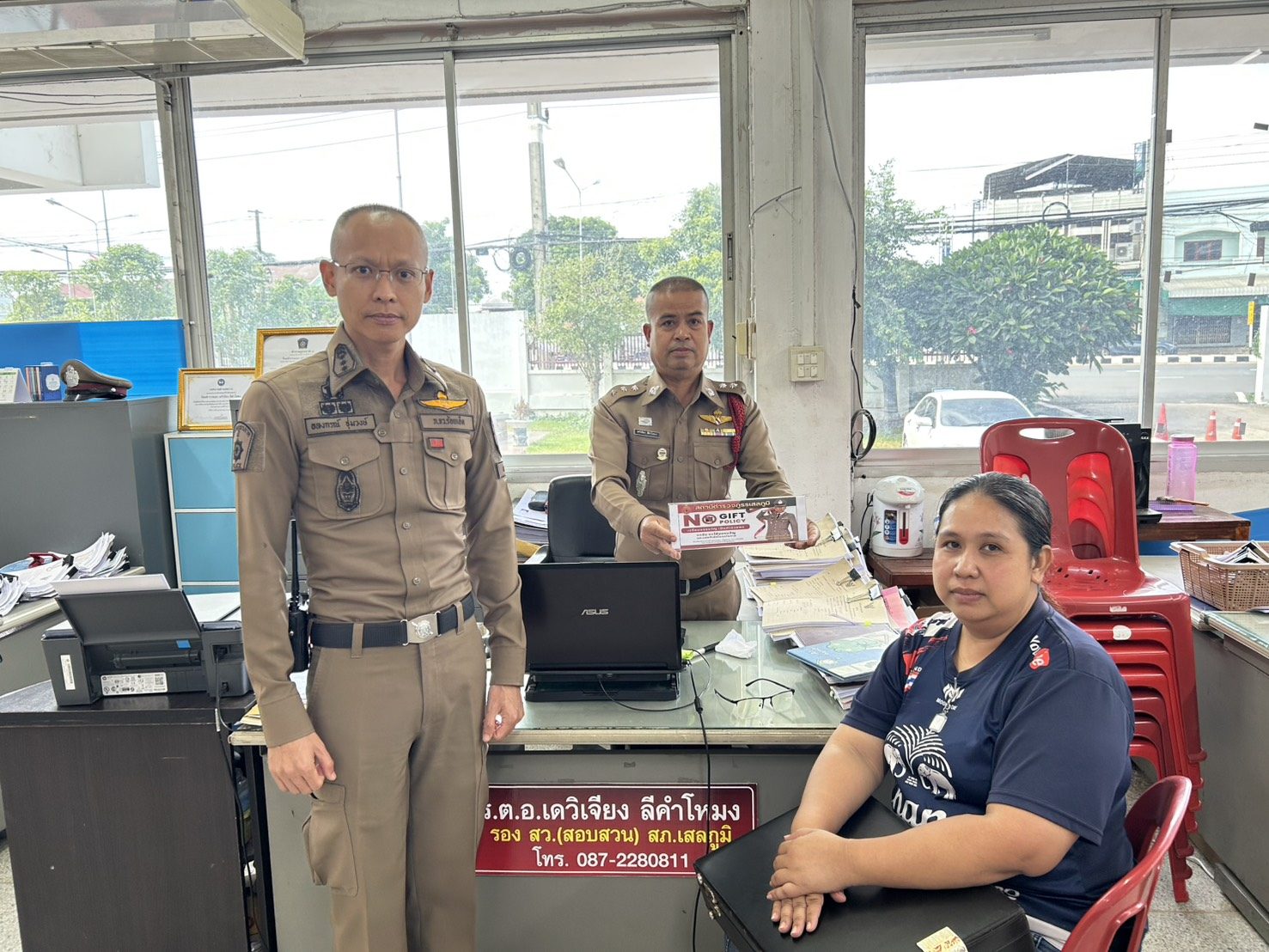 โต๊ะพนักงานสอบสวน — แสดงป้ายนโยบายต่อประชาชนผู้มาติดต่อราชการ